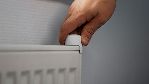 Hand draait aan een radiatorknop